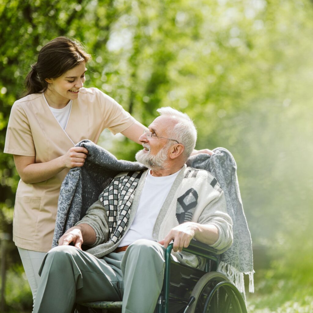 domiciliary care, carer putting shawl over client in wheelchair